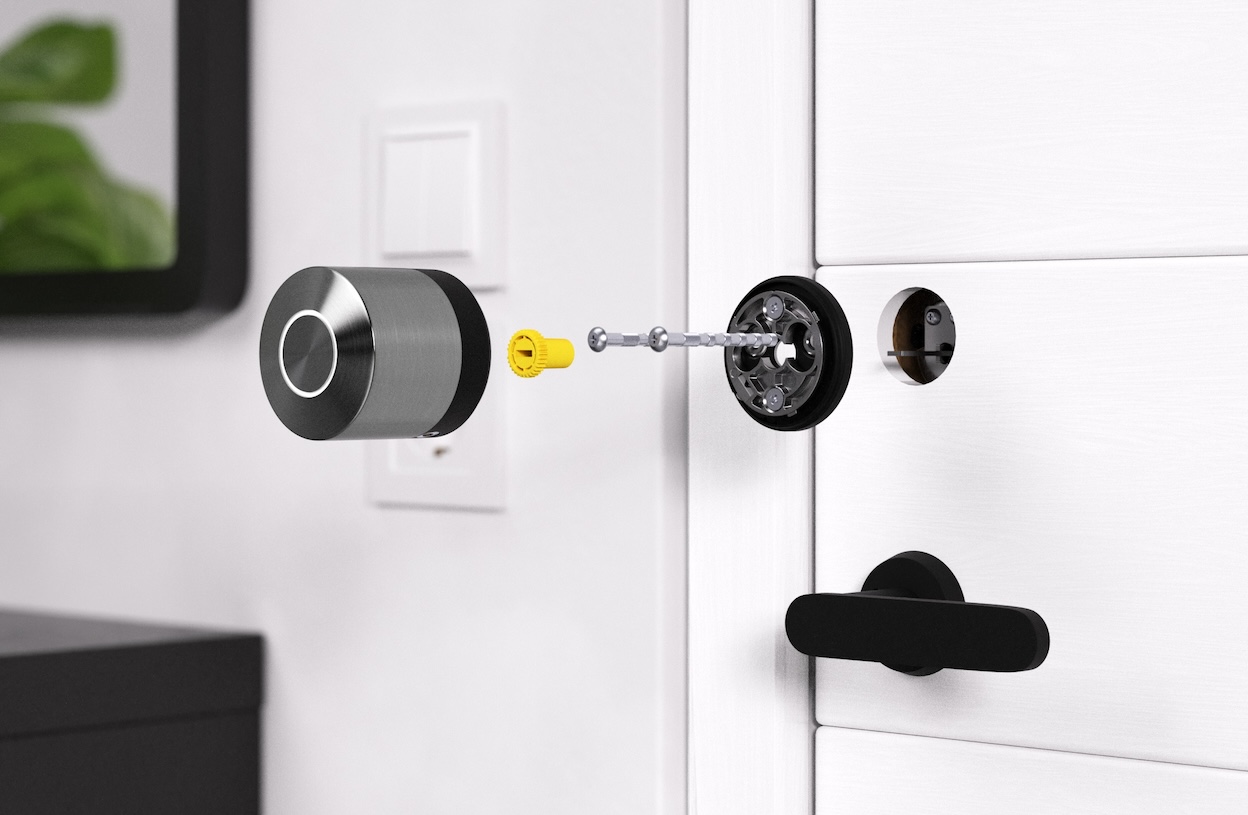verview of mounting the Smart Lock Nordics: The mounting plate is fixed to the door with screws. Next, an adapter is placed on the mounting plate. The Smart Lock then goes on top of that.